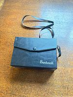 Black Bushnell carry case with shoulder strap
