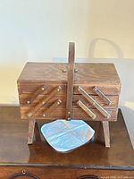 Closed wooden cantilever sewing box on legs with handle