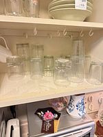 Multiple clear glasses with different textures on shelf