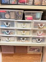 Front view of stacked clear plastic drawers with contents visible