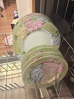 Stack of eight floral rim plates in dishwasher rack