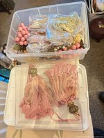 overview of two clear bins, top bin with berry picks and garland, lower bin with tassels