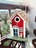 Front view showing entrance hole, door, window, ladder, perch