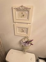 Overall view of connected frames above metal cone planter on wall