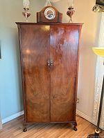 Front view of closed mahogany armoire showing overall form and finish