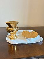 Urn vase and heart dish on cloth showing overall form and gold finish