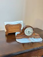Front view of oak tambour clock and oak napkin holder on table