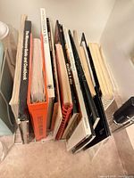 Stack of assorted cookbooks and pamphlets showing variety of bindings and thicknesses