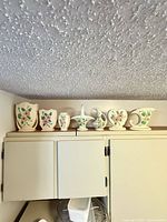 All seven Hull Pottery pieces lined up on cabinet
