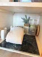 Shelf view showing towel, pitcher, basket, jar, plant, trivet, marble board