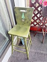 Full view of olive green wooden counter stool on balcony