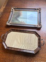 Framed artwork and wooden tray on surface