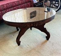 Full view of oval glass-top table showing base and glass