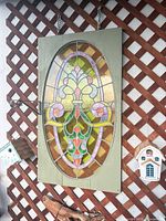 Full view of stained glass panel hanging on lattice