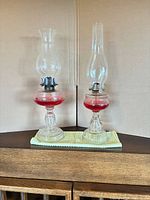 Both kerosene lamps on cabinet showing full height and form