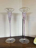 Pair of tall light purple amethyst glass candlesticks side by side