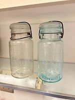 Front view of both jars showing color difference and closures