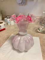 Vase side view showing bulbous ribbed base and ruffled rim