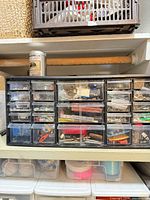 Front view of organizer filled with hardware, spray can visible on top