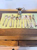 Group view of all flatware and creamer on towel