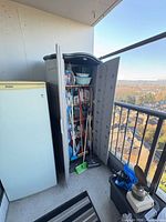 Cabinet open showing interior shelves, cleaning tools and supplies