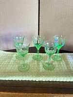 Five green uranium cordial glasses on cloth