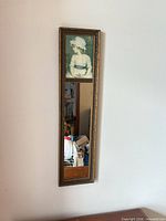 Full view of narrow Victorian-style wall mirror hung on wall