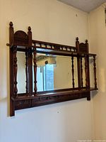 Full view of wall-mounted mirror shelf showing overall design and condition