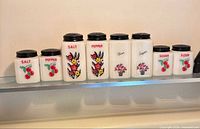 Full lineup of eight milk glass containers on shelf