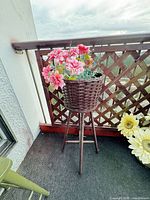 Full view of wicker planter with tripod legs on balcony
