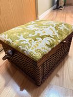 Closed wicker storage box showing upholstery and side knob