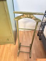 Front view of olive green wooden valet stand