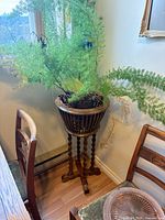 full view of wooden barley-twist plant stand beside chairs