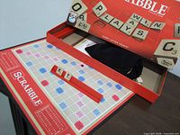 Open Scrabble box with board, rack and tiles shown