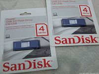 Front view of two sealed 4GB SanDisk Cruzer USB 2.0 flash drives