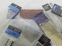 Group of sealed packs showing rhinestone and pearl sheets plus mosaic squares
