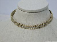 Front view of gold-tone rhinestone choker on display bust