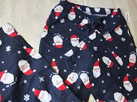 Navy cotton flannel pajama bottoms with Santa print displayed flat showing waistband and leg