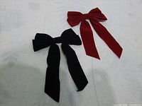 Front view of both velvet bow hair clips, red and black