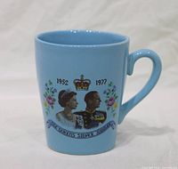 Front view showing portrait, dates 1952 1977, crown and floral design