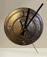 Front view of Ford hubcap wall clock showing numerals and hands