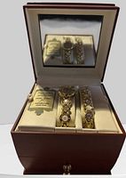 Watch and bracelet displayed in open wood box showing interior mirror