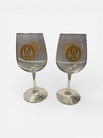 Both wine glasses front view showing gold-tone crest