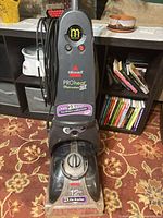 Front view of carpet cleaner showing branding, tank and brush nozzle