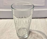 Front view of clear pint glass showing frosted word art.