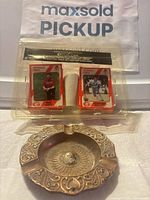 Front view of sealed card set and brass ashtray