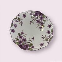 Front view showing full violet floral design, scalloped gold rim, reticulated handle