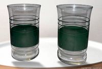 Two green band shot glasses close view