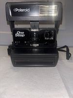 Front view showing Polaroid branding, OneStep label, flash, lens, and film door
