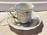 Cup resting on saucer showing blue floral and platinum trim